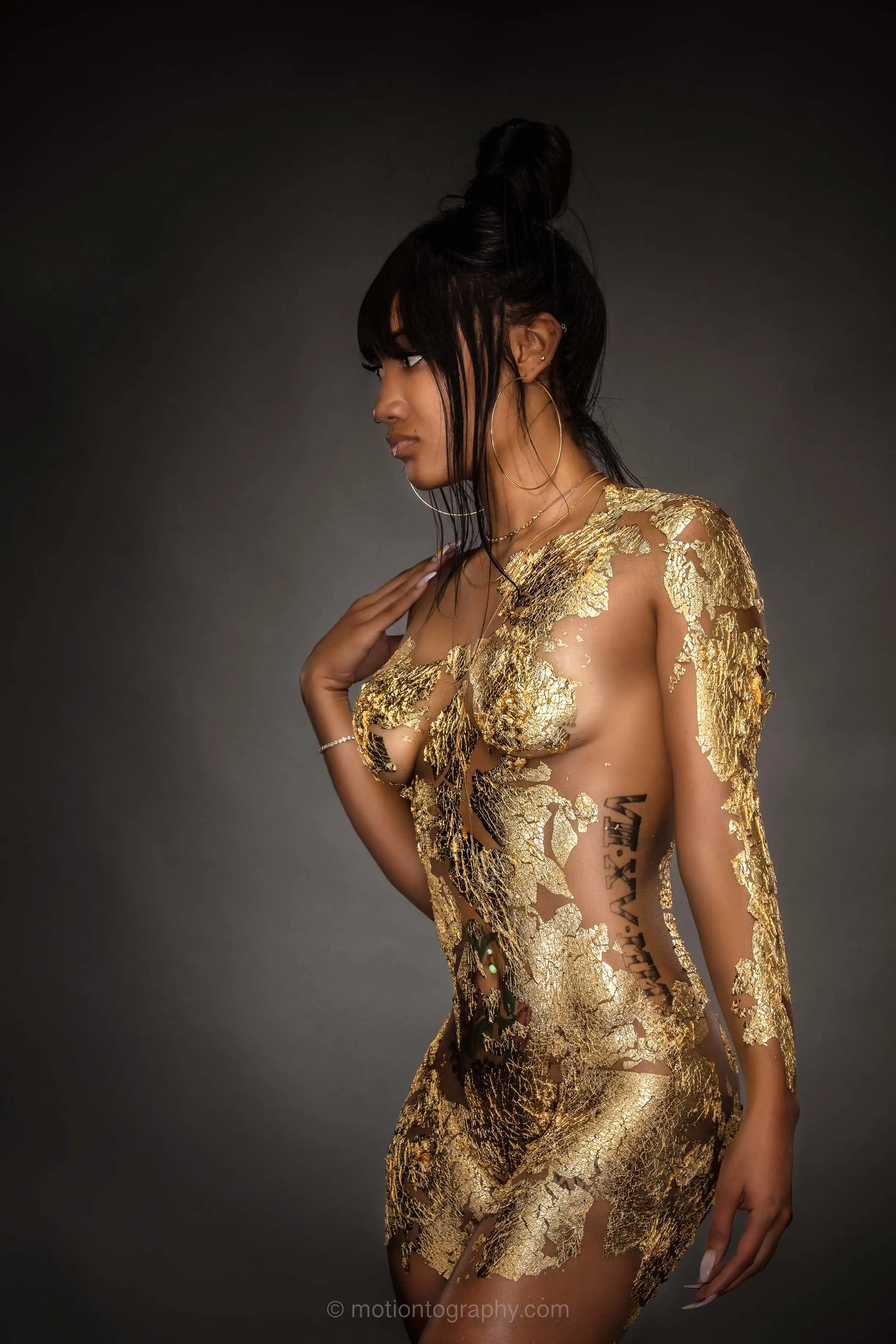 Artistic boudoir portrait featuring gold body paint