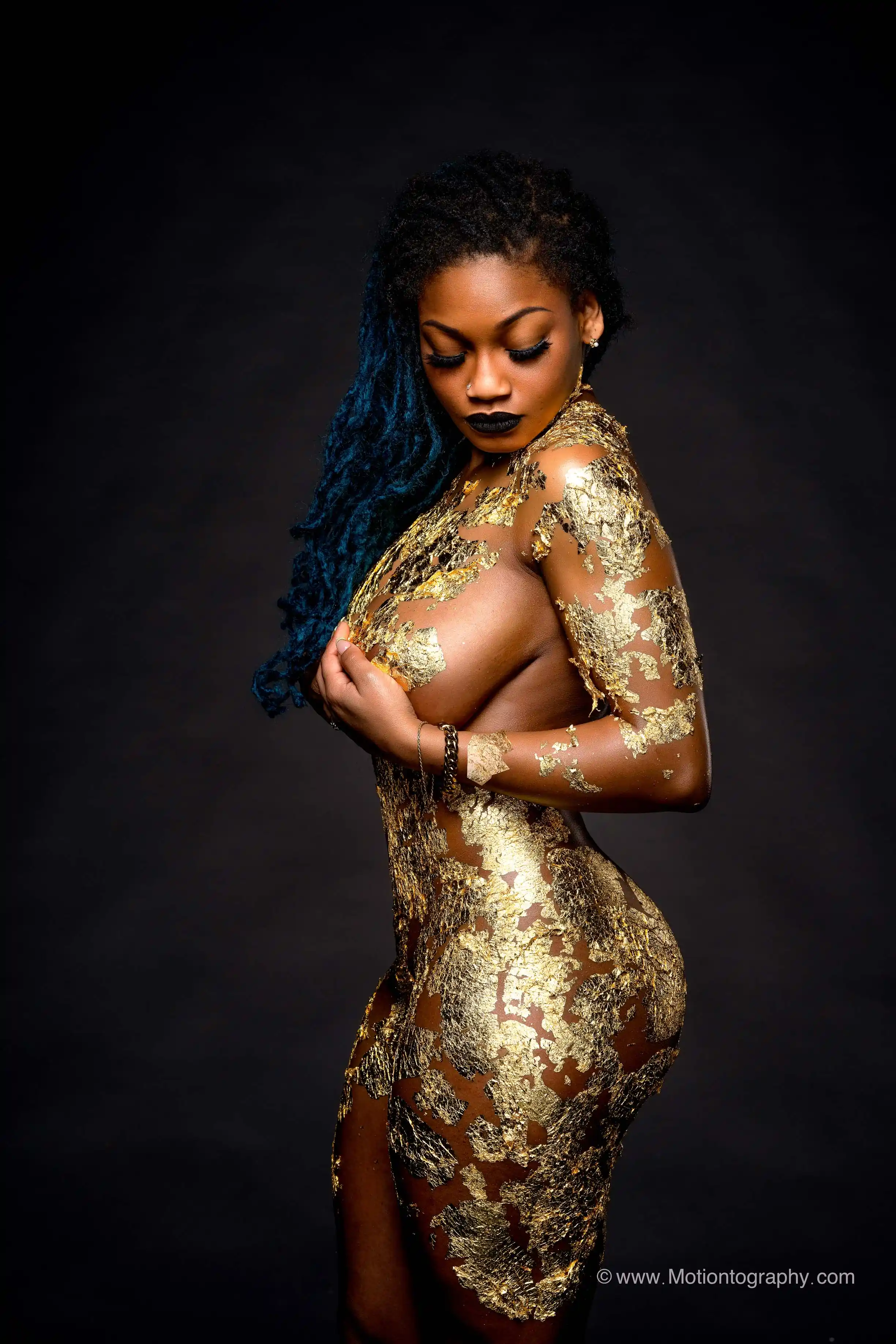 Unique boudoir portrait with gold body paint and dreadlocks