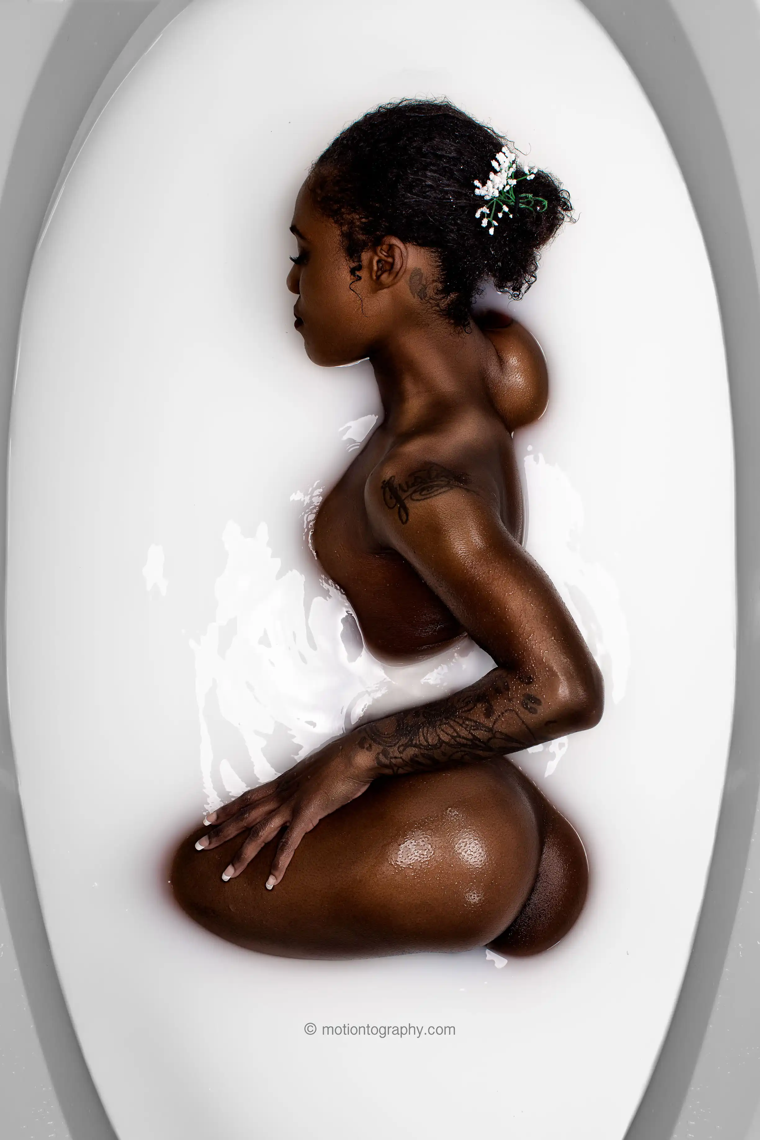 Sensual milk bath boudoir photo with tattoos