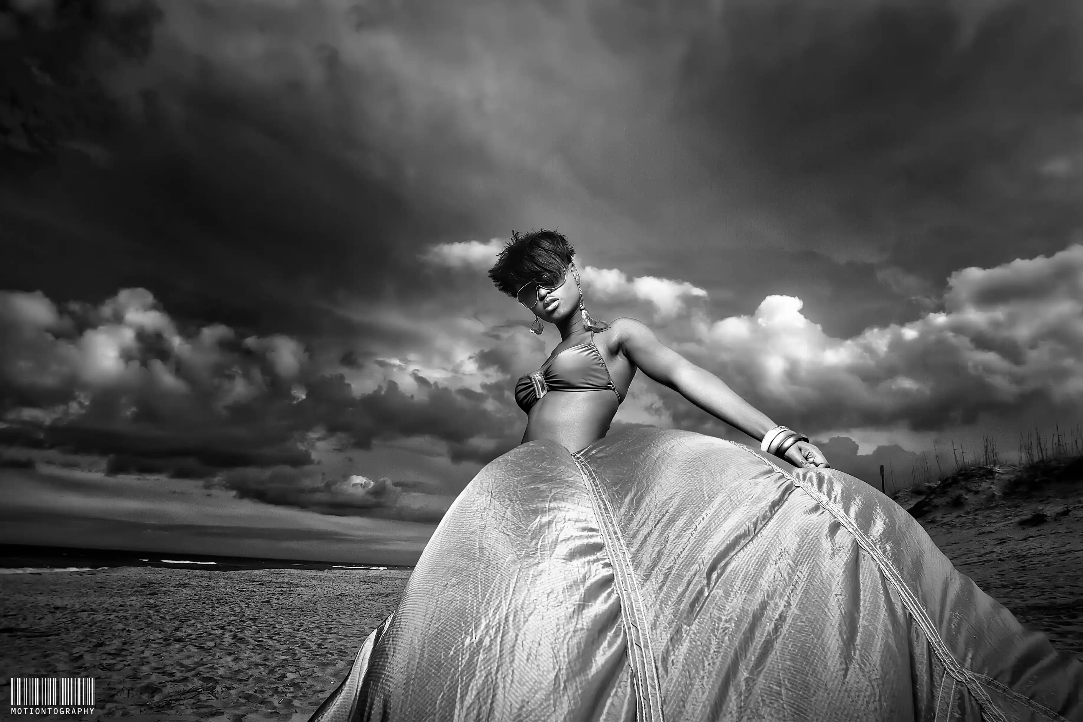 On location dramatic beach photo parachute dress storm clouds