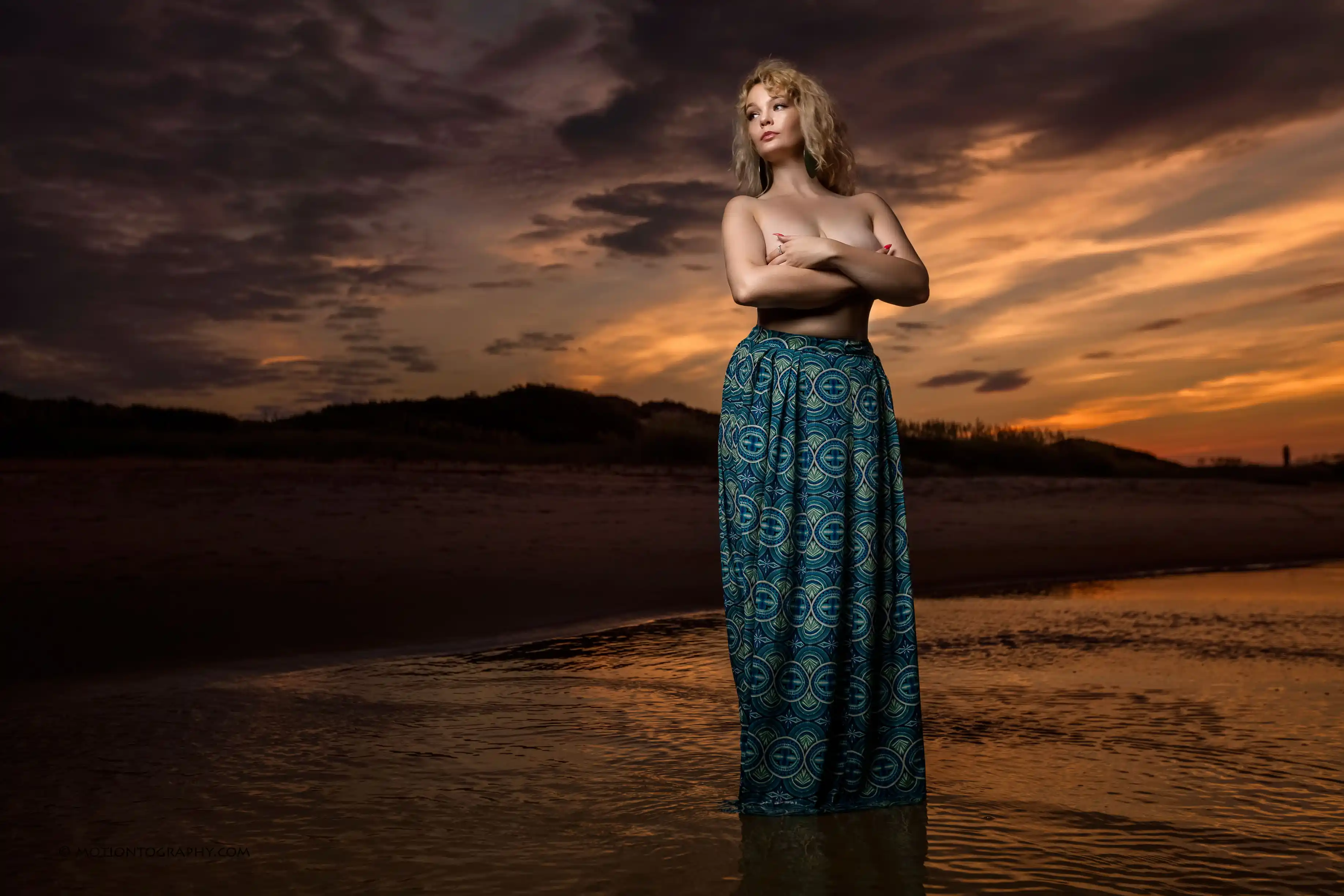 On location beach sunset photo woman long skirt dramatic sky