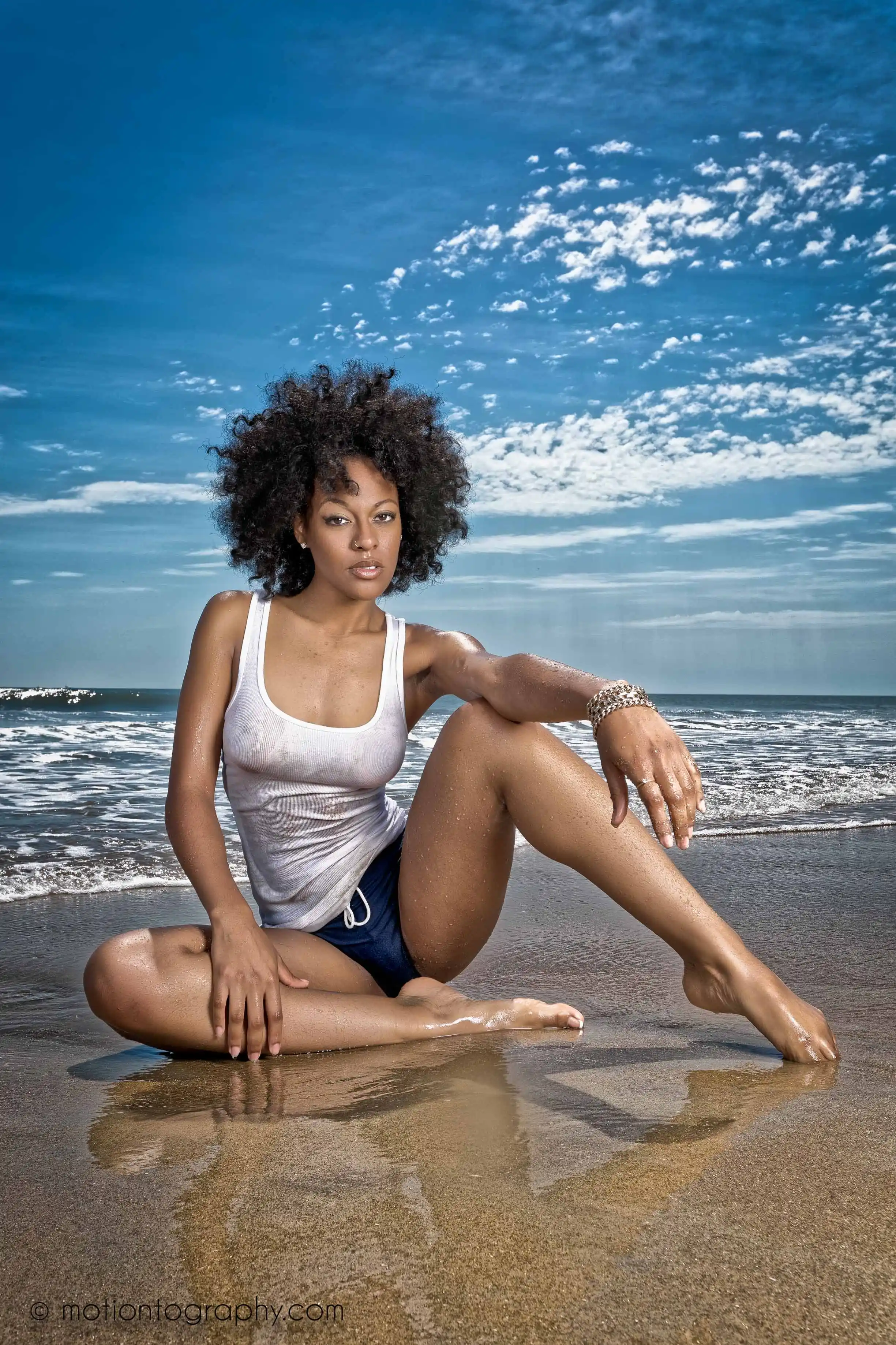 On location beach photo woman sitting white tank top wet look