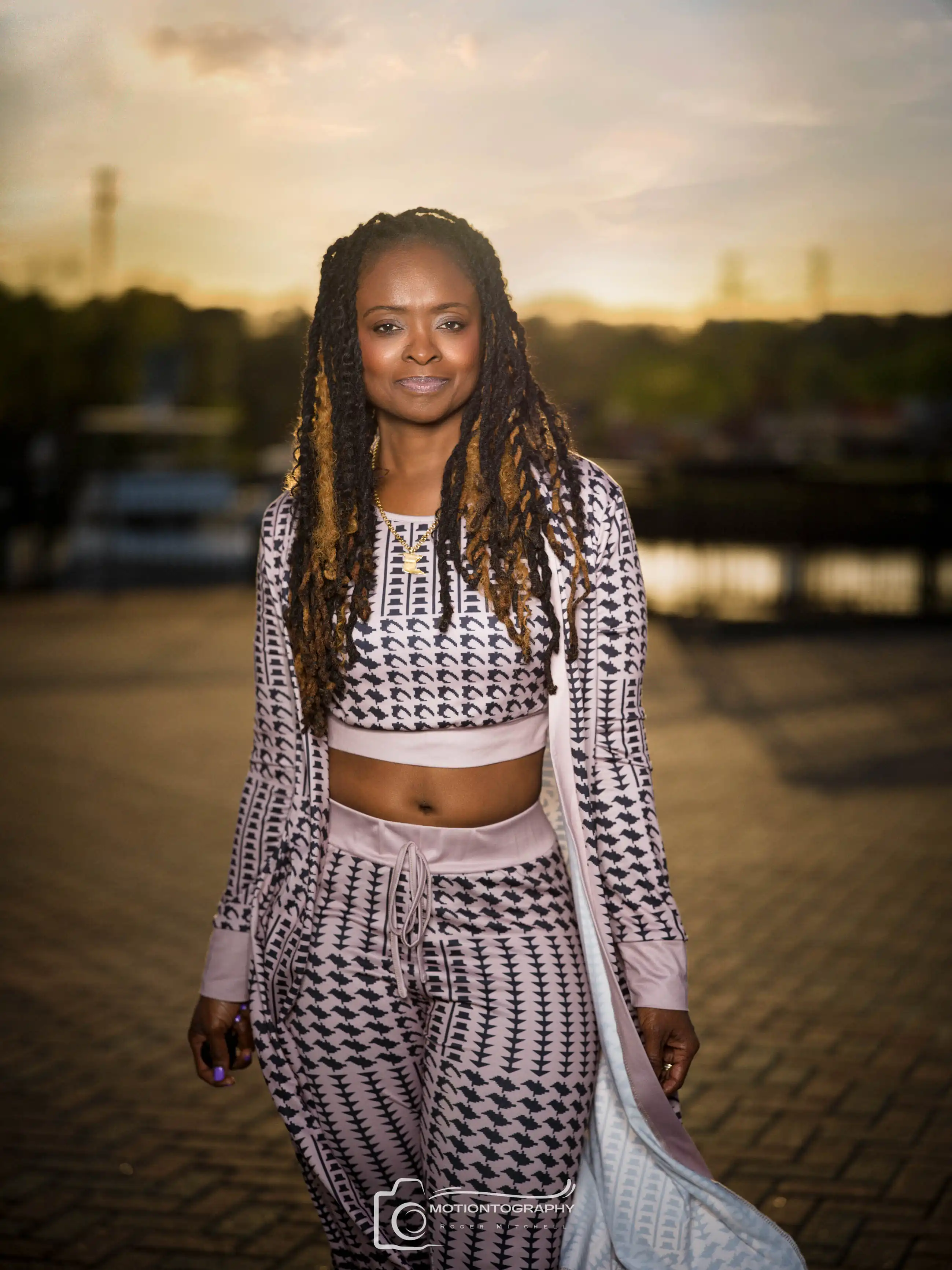 On location outdoor portrait woman smiling sunset dreadlocks