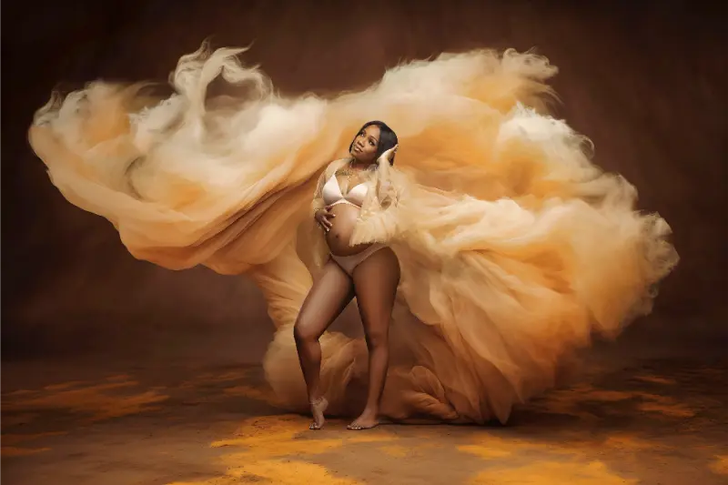 Maternity portrait with flowing golden fabric